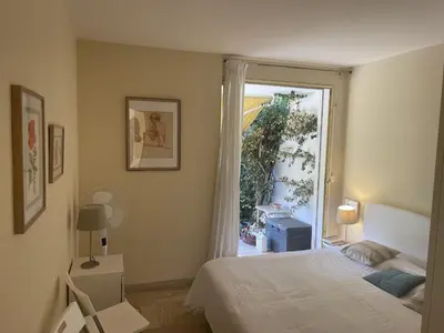 a bedroom with a bed and a sliding glass door at Les Oliviers 3, Domaine de Pierre Longue in Cannes