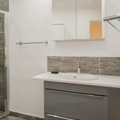 a white bathroom with a sink and a mirror at Les Oliviers 3, Domaine de Pierre Longue in Cannes