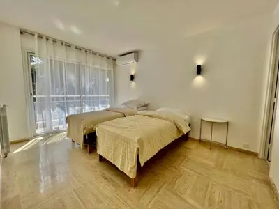 a bedroom with two beds and a large window at 90 m2, 5 min walk to Croisette, Basse Californie in Cannes