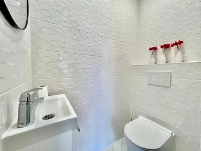 a white bathroom with a toilet and a sink at 90 m2, 5 min walk to Croisette, Basse Californie in Cannes
