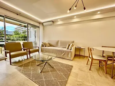 a living room with a couch and a table and chairs at 90 m2, 5 min walk to Croisette, Basse Californie in Cannes