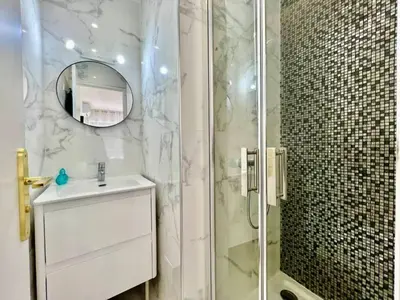 a bathroom with a shower with a sink and a mirror at 90 m2, 5 min walk to Croisette, Basse Californie in Cannes