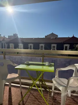 a green table and two chairs on a balcony at Central location, terrace, 2 bedrooms in Cannes