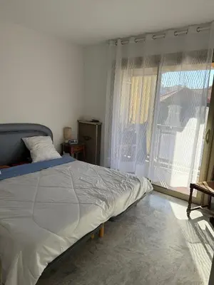 a bedroom with a bed and a large window at Central location, terrace, 2 bedrooms in Cannes