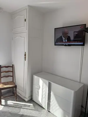 a white living room with a tv on a wall at Central location, terrace, 2 bedrooms in Cannes
