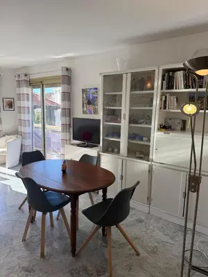 a living room with a wooden table and chairs at Central location, terrace, 2 bedrooms in Cannes