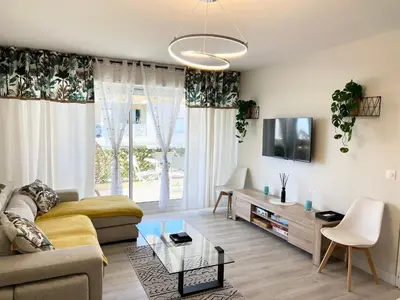 a living room with a couch and a tv at Paradis in Cannes