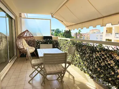 a patio with a table and chairs on a balcony at Paradis in Cannes