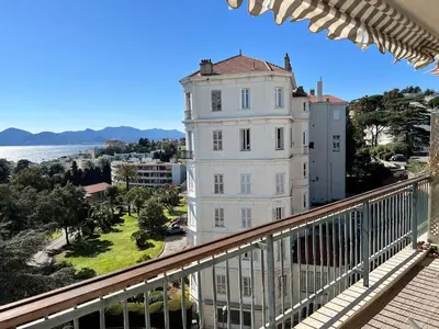 a white building on a balcony next to the water at Cannes Blue Riviera Luxe in Cannes