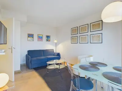 a living room with a blue couch and a table at Centre Cannes Suquet in Cannes