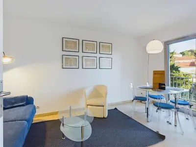 a living room with a couch and a table and chairs at Centre Cannes Suquet in Cannes