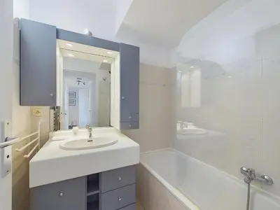 a white bathroom with a sink and a tub and a tubermott at Centre Cannes Suquet in Cannes