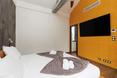 a bedroom with a bed with a tv on a wall at Immogroom - Exceptional Villa Near Croisette in Cannes