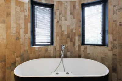a bath tub in a room with two windows at Immogroom - Exceptional Villa Near Croisette in Cannes