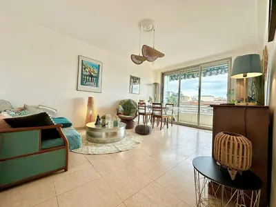 a living room with a couch and a table at Nice 1 bedroom, sea view, 10 min from Cannes Center & Palais des Festivals in Cannes
