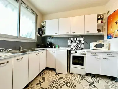 a kitchen with white cabinets and a sink and a microwave at Nice 1 bedroom, sea view, 10 min from Cannes Center & Palais des Festivals in Cannes