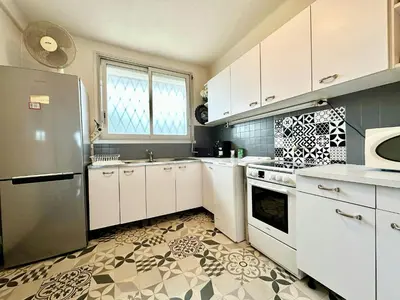 a kitchen with white cabinets and a refrigerator at Nice 1 bedroom, sea view, 10 min from Cannes Center & Palais des Festivals in Cannes