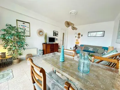 a living room with a table and a couch at Nice 1 bedroom, sea view, 10 min from Cannes Center & Palais des Festivals in Cannes