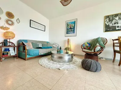 a living room with a couch and a table at Nice 1 bedroom, sea view, 10 min from Cannes Center & Palais des Festivals in Cannes
