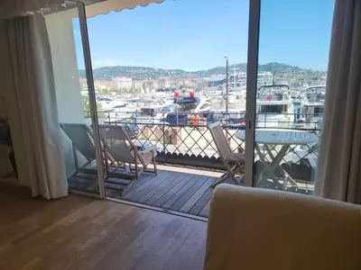 a balcony with chairs and a view of a marina at PORT DE CANNES SUPERBE 3 Pièces in Cannes