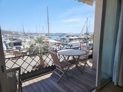 a balcony with a table and chairs and a marina at PORT DE CANNES SUPERBE 3 Pièces in Cannes
