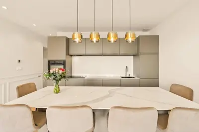 a dining room with a white table and chairs at LES SUITES DU PALAIS sur LA CROISETTE - Vue MER in Cannes
