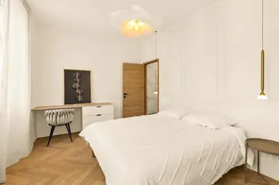 a white bedroom with a white bed and a table at LES SUITES DU PALAIS sur LA CROISETTE - Vue MER in Cannes