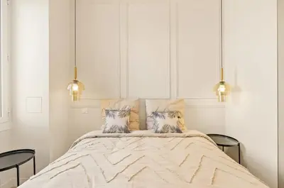 a bedroom with a large bed with two pillows at LES SUITES DU PALAIS sur LA CROISETTE - Vue MER in Cannes