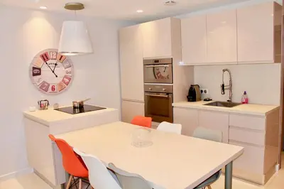 a kitchen with a table and chairs and a clock at REF 2003 - Cannes Croisette - 3 mins from the Croissette in Cannes