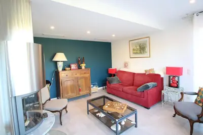 a living room with a red couch and a table at Peaceful villa with pool and garden - 5 minutes from Cannes beaches in Cannes