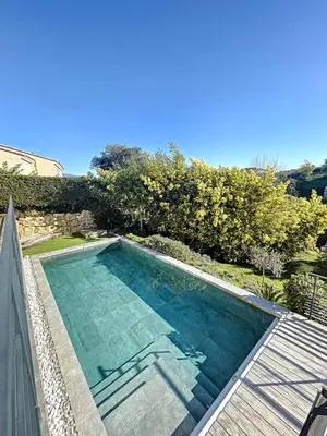 a swimming pool on the side of a house at Peaceful villa with pool and garden - 5 minutes from Cannes beaches in Cannes