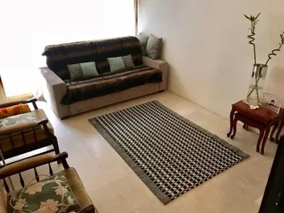 a living room with a leather couch and a rug at Apartement Centre Cannes, 80m de la plage Martinez in Cannes