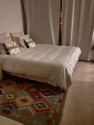 a bed with pillows on top of a rug at Apartement Centre Cannes, 80m de la plage Martinez in Cannes