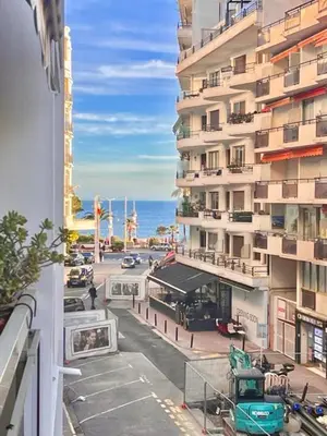 a view of a street with a building and the ocean at Apartement Centre Cannes, 80m de la plage Martinez in Cannes