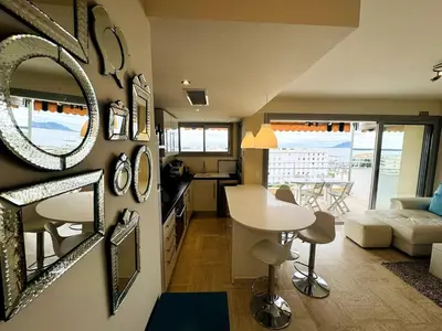 a kitchen and a living room with a table in a room at Seaview Retreat 1BR with terrace in Cannes