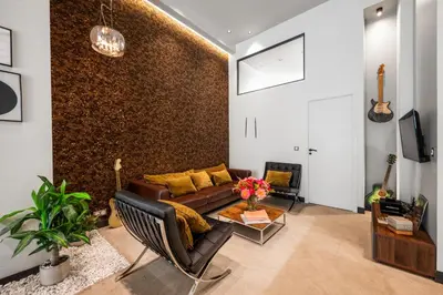 a living room with a brown couch and a wall at Jessicannes - Architect loft near Croisette in Cannes