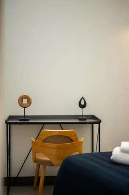 a desk with a wooden chair next to a bed at Jessicannes - Architect loft near Croisette in Cannes