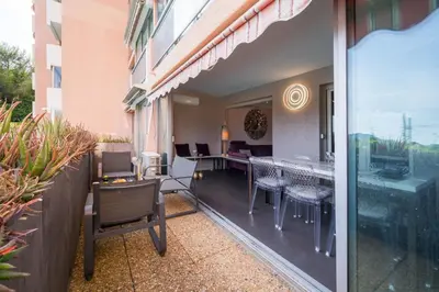 a balcony with tables and chairs on a building at Cannes plage - avec terrasse, vue, mer, piscine, plage, garage in Cannes
