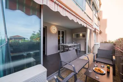 a patio with a table and chairs on a balcony at Cannes plage - avec terrasse, vue, mer, piscine, plage, garage in Cannes