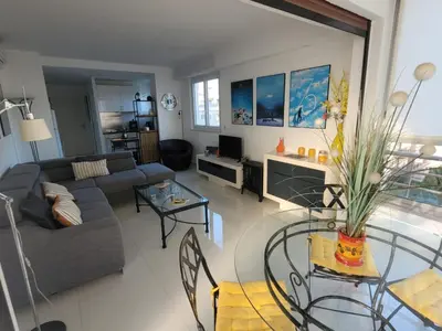 a living room with a couch and a table at Center Cannes Hippocampe in Cannes