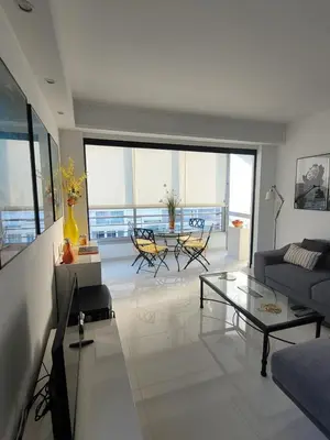 a living room with a couch and a glass table at Center Cannes Hippocampe in Cannes