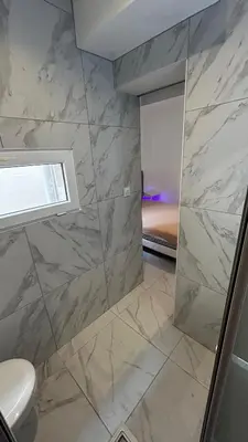 a bathroom with a shower with marble tiles at La Pitchounette bord de mer in Cannes