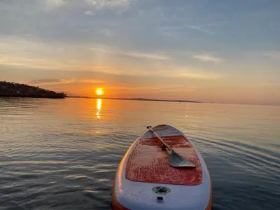 a paddle boat in the water at sunset at La Pitchounette bord de mer in Cannes
