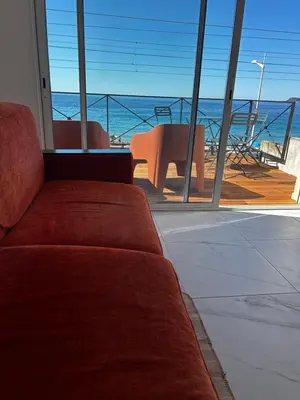 a couch in a room with a view of the ocean at La Pitchounette bord de mer in Cannes