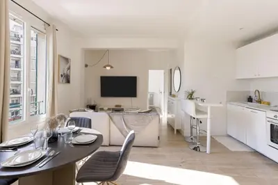 a kitchen and living room with a table and chairs at Astéria - cosy, moderne, clim, 15mn Palais&Plages in Cannes