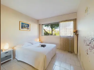 a bedroom with a white bed and a window at Center Cannes Montfleury in Cannes