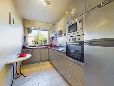 a kitchen with stainless steel appliances and a table at Center Cannes Montfleury in Cannes