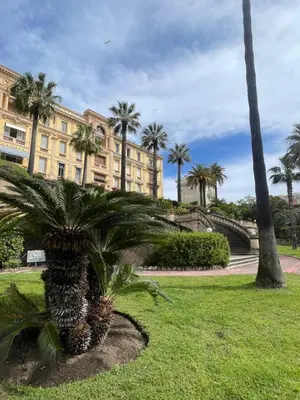 a palm tree in front of a building at Parc Continental Apartment with sea view in Cannes