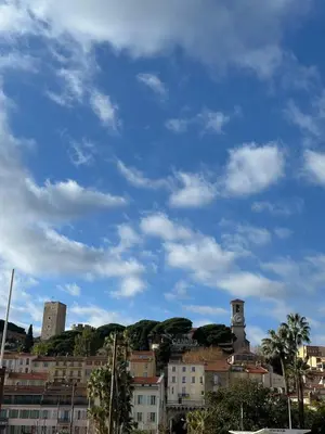a city with buildings and a blue sky with clouds at Parc Continental Apartment with sea view in Cannes