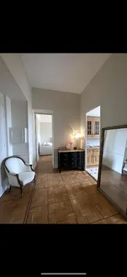 an empty living room with a chair and a table at Parc Continental Apartment with sea view in Cannes